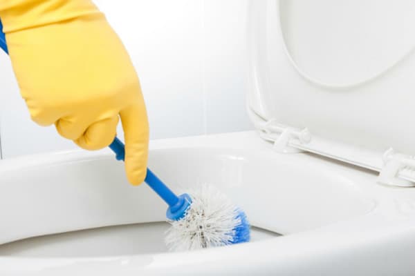 Nettoyer les toilettes avec une brosse