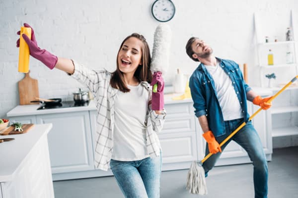 Jeune couple s'amuser pendant le nettoyage.