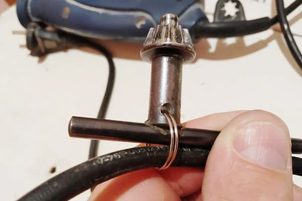 Fixer la clé de la perceuse au fil avec un anneau en métal